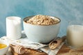 Composition oatmeal flakes and milk on white table. Cooking breakfast