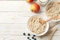 Composition oatmeal porridge on white wooden background. Cooking breakfast