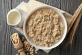 Composition oatmeal porridge on wooden background. Cooking breakfast