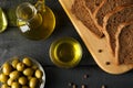 Composition with olive oil, bread and olives on background, top view