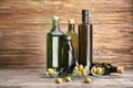 Composition with olives and oil in bottles on wooden background Royalty Free Stock Photo