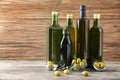 Composition with olives and oil in bottles on wooden background Royalty Free Stock Photo