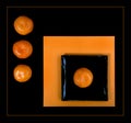 Composition of orange mandarin and black square plate on an orange table Royalty Free Stock Photo