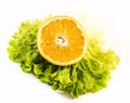 Composition of an orange with salad on a white background Royalty Free Stock Photo