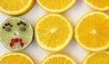 Composition of orange slices with one green lime slice with unhappy face. Royalty Free Stock Photo