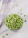 Composition with organic frozen vegetables on a white wooden background. Green peas and sprouts in a bowl. Royalty Free Stock Photo