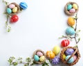 Composition with painted Easter eggs and blossoming branches on white background