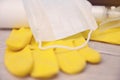 Composition of a pair of yellow latex gloves with white plastic bottle with atomizer and white medical face mask