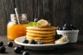 Composition with pancakes, banana blueberry and jam on wooden background