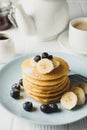 Composition with pancakes banana and blueberry on wooden background. Sweet breakfast