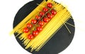 Composition of pasta fresh tomato, on black stone board, white background. Royalty Free Stock Photo