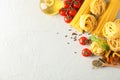 Composition with pasta, tomatoes, spices and olive oil on white background