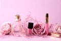 Composition with perfume, cosmetics and roses on pink background