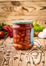 Composition of pickled beans with tomato in jar and ingredients