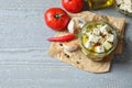 Composition with pickled feta cheese in jar on grey wooden table. Space for text Royalty Free Stock Photo