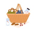 Composition of picnic basket with bottle of milk, fruits, berries, chocolate cookies and pretzels for outdoor romantic