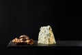 Composition of pieces of blue cheese and walnut on black background Royalty Free Stock Photo