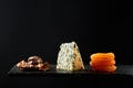 Composition of pieces of walnut and hard cheese and dried apricot on black background Royalty Free Stock Photo