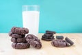 Composition with pile of choco biscuits, chocolate pieces and glass of milk on blue background Royalty Free Stock Photo