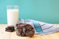 Composition with pile of choco biscuits, chocolate pieces and glass of milk on blue background Royalty Free Stock Photo