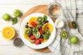 Composition plate of fresh fruit salad on white wooden table, top view Royalty Free Stock Photo