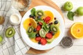 Composition plate of fresh fruit salad on white wooden table, top view Royalty Free Stock Photo