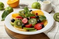 Composition plate of fresh fruit salad on wooden background, close up Royalty Free Stock Photo