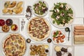 Composition with plates of pizza, tartlets, salads, sandwiches, empanadas, entrees and Argentine cakes