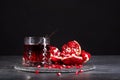 A composition of a pomegranate drink and cut garnet on a black background. Refreshing red cocktails. Royalty Free Stock Photo