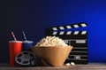 Composition with popcorn, cinema clapperboard and film reel on table