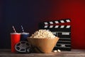 Composition with popcorn, cinema clapperboard and film reel on tabl Royalty Free Stock Photo