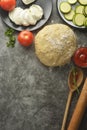 Composition with raw dought and fresh ingredients for pizza isolated on dark background. Copy space. Flat lay food ingredients Royalty Free Stock Photo