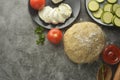 Composition with raw dought and fresh ingredients for pizza isolated on dark background. Copy space. Flat lay food ingredients Royalty Free Stock Photo
