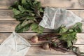 Composition of raw fresh clean beetroots with stems in special organic degradable transparent bags on wooden background