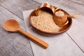 Composition with raw rice in a wooden brown bowl with a wooden spatula and a spoon. Royalty Free Stock Photo