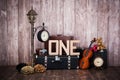 Composition in retro style, old suitcases, a lantern with a clock, a violin and a word one Royalty Free Stock Photo