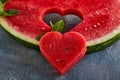 Composition with ripe watermelon, mint leaves and a heart carved in a slice of watermelon. Concept for valentines day