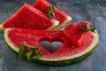 Composition with ripe watermelon, mint leaves and a heart carved in a slice of watermelon. Concept for valentines day
