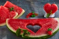 Composition with ripe watermelon, mint leaves and a heart carved in a slice of watermelon. Concept for valentines day