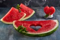 Composition with ripe watermelon, mint leaves and a heart carved in a slice of watermelon. Concept for valentines day