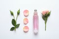 Composition with rose essential oil and flowers on white, top view Royalty Free Stock Photo