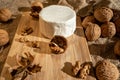 Composition of a round cheese head with white mold and walnuts on a bamboo board on a background of burlap Royalty Free Stock Photo