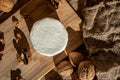 Composition of a round cheese head with white mold and walnuts on a bamboo board on a background of burlap Royalty Free Stock Photo