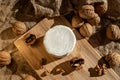 Composition of a round cheese head with white mold and walnuts on a bamboo board on a background of burlap Royalty Free Stock Photo