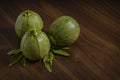 Composition of round pumpkins with epazote leaves on wooden table