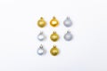 Composition of rows of gold and silver baubles on white background