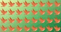 Composition of rows of orange birds on green background
