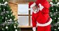 Composition of santa claus carrying gift sack by christmas trees against window, copy space Royalty Free Stock Photo