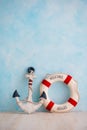 A composition on a sea theme with an anchor and lifebuoy on a blue wall Royalty Free Stock Photo