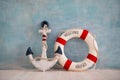 A composition on a sea theme with an anchor and lifebuoy on a blue wall Royalty Free Stock Photo